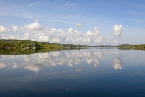 View over the Möhnesee, Möhnesee tower, red and white buoy, blue cloudy sky, reflection on the