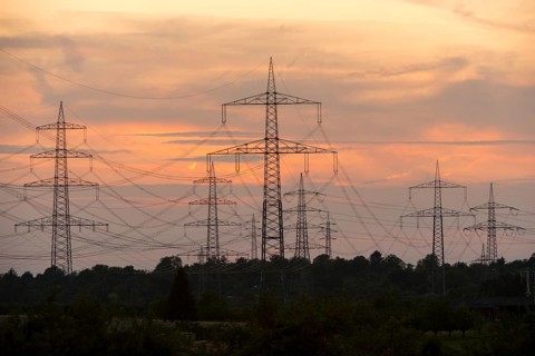 Electricity pylons in front of a pastel-coloured sunset sky with clouds, Waiblingen,