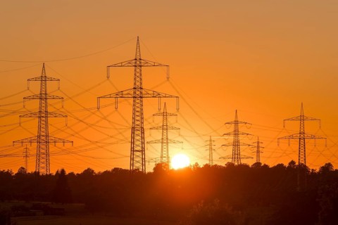 Electricity pylons in front of a glowing sunset on the horizon, Waiblingen, Baden-Württemberg,