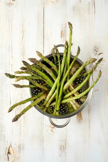 Freshly harvested asparagus resting in a colander ready for cooking or preparation