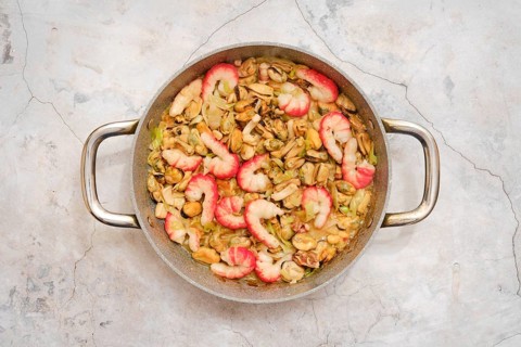 Overhead view of pan with tender shrimp, octopus and mussels with leek