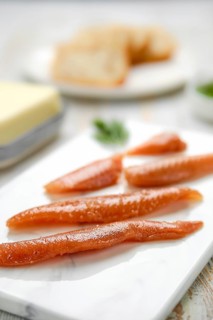 Herring caviar glisten with a rich color, artfully arranged on a marble platter. In the background,