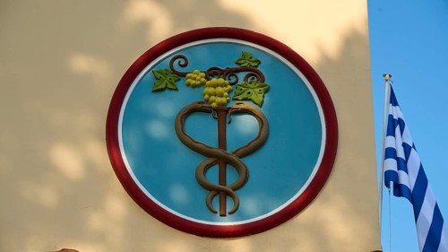 Town Hall, circular emblem with snake and vine, flanked by Greek flag, Kos Town, Kos, Dodecanese,
