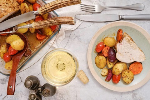 A plate with tender slices of turkey breast alongside colourful roasted vegetables, including
