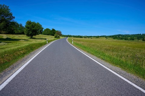Rural road leads through green meadows under a clear blue sky, summer, Franzosenweg, Lange Rhön,