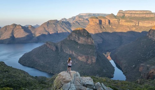 Hiker enjoying panorama, Blyde River Canyon with summit Three Rondawels, view of canyon with river
