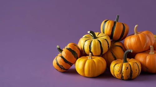 Close up of small orange pumpkins with stripes on purple banner with copy space. Generative ai, AI