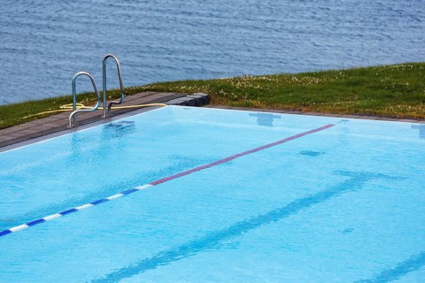View from above of swimming pool by the sea, thermal bath, heated outdoor pool in Hofsos at the