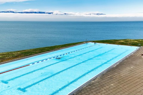 View from above of infinity pool by the sea, thermal bath, heated outdoor pool in Hofsos by