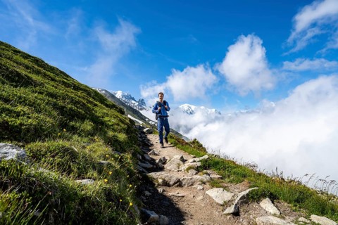 Mountaineer on a hiking trail, inversion weather situation with clouds in the valley, Chamonix,