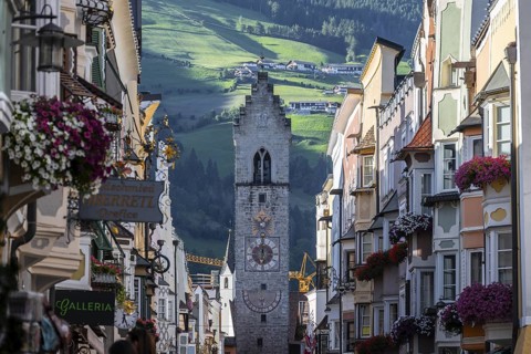 Old town, colourful houses in the main street, Zwölferturm tower at the back, Sterzing, South