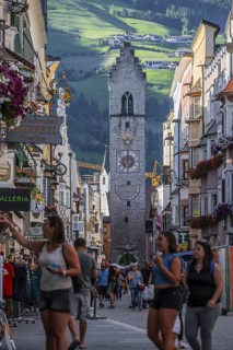Tourists in the old town, colourful houses in the main street, Zwölferturm tower at the back,