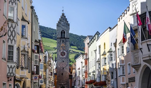 Old town, colourful houses in the main street, Zwölferturm tower at the back, old town, Sterzing,