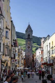 Old town, colourful houses in the main street, Zwölferturm tower at the back, old town, Sterzing,