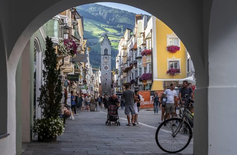 Passageway, old town, colourful houses in the main street, Zwölferturm tower at the back, Sterzing,