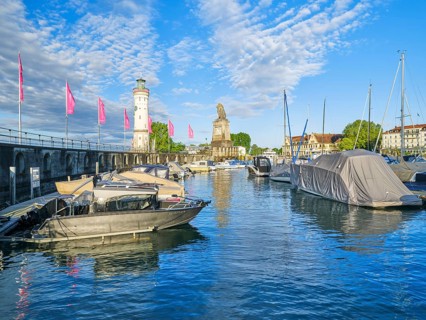 Harbour with lighthouse and lion statue in Lindau, Lake Constance, lake, blue sky, morning, boats,