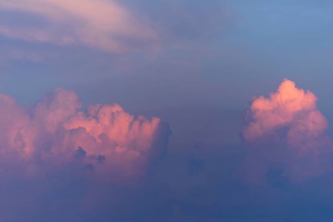 Soft pink and purple clouds float against a blue sky, capturing the calming beauty of twilight.