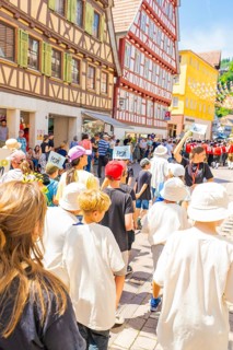 Group of children marching through a historic street during a parade, 950 years of Calw, Calw