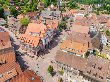 Aerial view of a colourful half-timbered town with a lively market square and church on a summer's