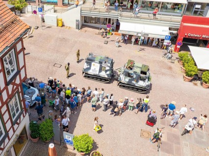 Street view with assembled spectators and military vehicles at an event, 950 years of Calw, Calw