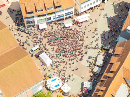 Vivid aerial view of a square where a crowd is taking part in a public celebration, 950 years of