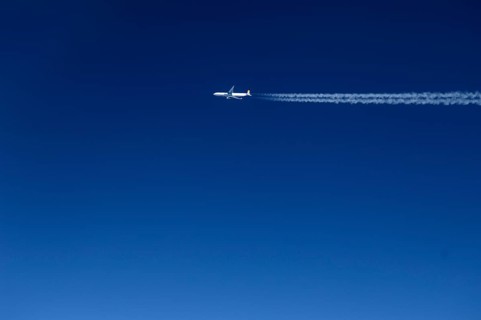 View of a passing aircraft in the blue sky at an altitude of 10, 000 metres, Atlantic flight to New