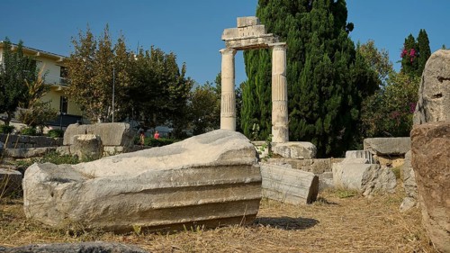 Debris of a fallen column lying on dry ground in front of a stone archway, Ancient Agora, Kos Town,