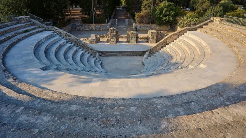 Round ancient theatre with ruined walls and stone steps surrounded by nature, Ancient Theatre,