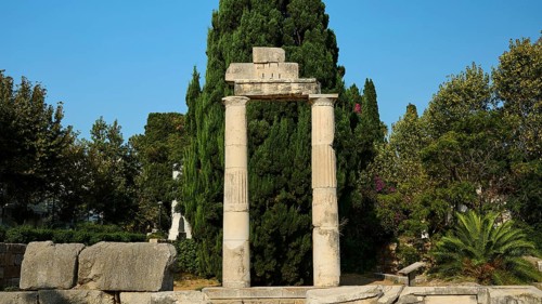 Ancient Tor tor with columns and dense green tree in the background, Ancient Agora, Kos Town, Kos,