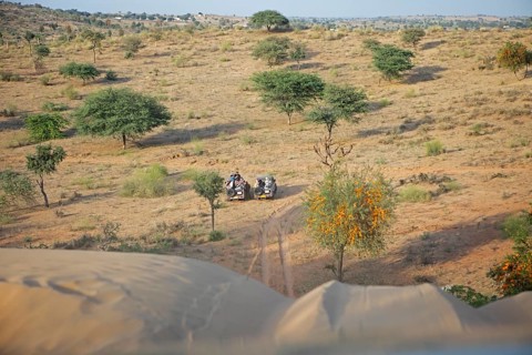 Jeeps waiting under a dune in the Thar Desert or Great Indian Desert, near Jaisalmer, Rajasthan,