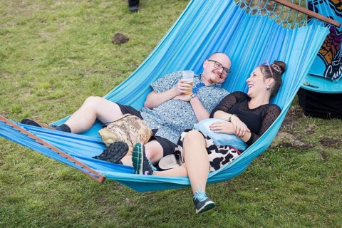 Two festival visitors lying in a hammock in the Fashion Palooza at the Lollapalooza Festival in the