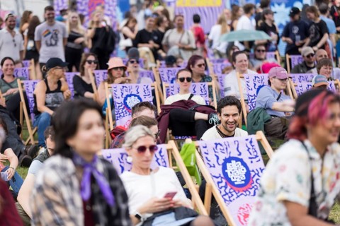 Festivalgoers on deckchairs have fun at the LGBTQTIES comedy in the Fashion Palooza at the