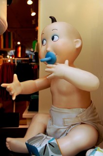 Baby mannequin with dummy in a children's shop, New York City, USA