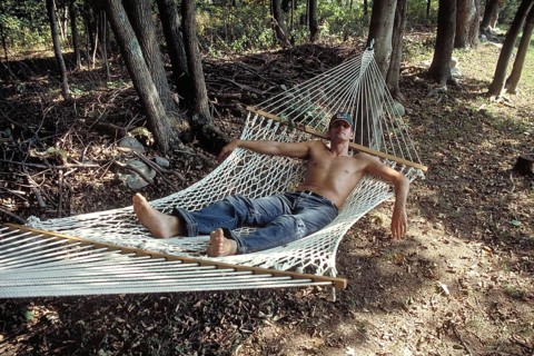 Young man with sunglasses and cap sleeping in a hammock, New Jersey, USA