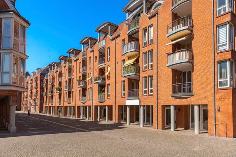Modern brick architecture, Teerhof peninsula, columns, balconies, cobblestones, street, blue sky,