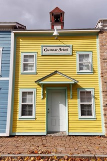 Replica, historic elementary school, yellow façade, sign, fall leaves, boutique hotel, theme hotel