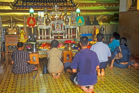 People praying in the temple with the Buddha statue Phra Mongkhonbophit, Ayutthaya, Thailand,