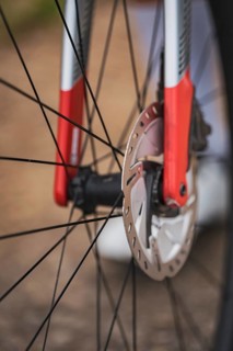 Close-up of a bicycle part with red and silver design showing the mechanics and brake disc,