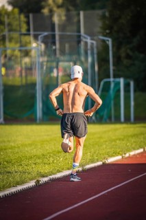 Runner jogging bare-chested on an outdoor running track, triathlon, Calw, Germany