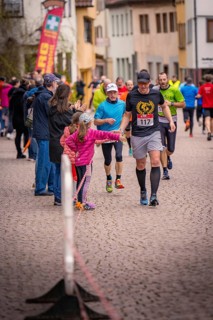 Runners clap off with spectators on a paved road, Triathlon, Calw, Germany