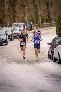 Two runners running on a road with parked cars and trees in the background, Triathlon, Calw,