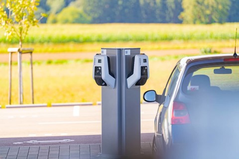 Electric vehicle at a charging station with a view of a natural landscape, e-charging park,