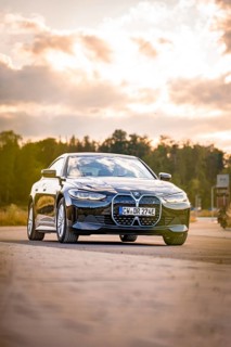 Black car on the road in natural setting at sunset, BMW i7 electric car, Deer E- Carsharing, Calw,