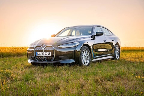 Black car in open field at sunset, natural environment, BMW i7 electric car, Deer E- Carsharing,