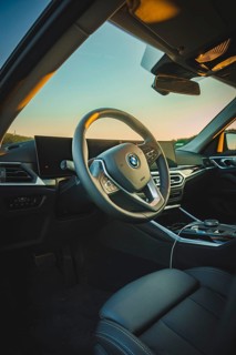 Modern car interior with stylish steering wheel and screens, in sunset light, BMW i7 electric car,