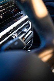 Close-up of a modern car interior with focus on steering wheel and dashboard, BMW i7 electric car,