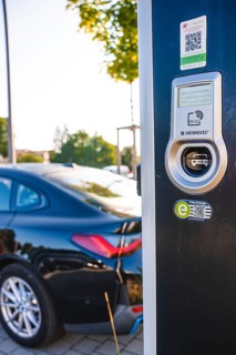 Electric car at a charging station, modern design with QR code and environmentally friendly
