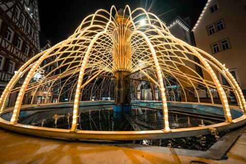 Close-up view of illuminated fountain with reflections in water, Calw, Black Forest, Germany