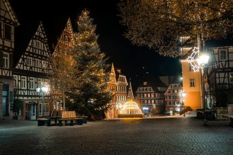Illuminated square in an old town with half-timbered houses, Christmas tree and festive decoration,