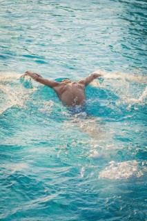 A swimmer in a blue pool moves powerfully through the water, Triathlon, Calw, Germany